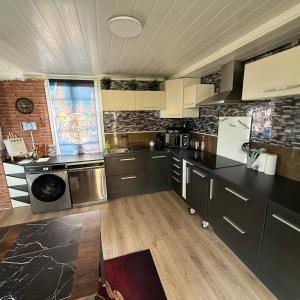 a kitchen with gray cabinets and a brick wall at La Clef d'Or in Magescq