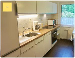 a kitchen with a sink and a microwave at Huus Negen in Neuharlingersiel