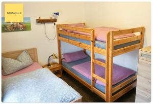a bedroom with two bunk beds with purple sheets at Huus Negen in Neuharlingersiel