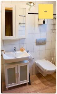 a bathroom with a sink and a toilet at Huus Negen in Neuharlingersiel