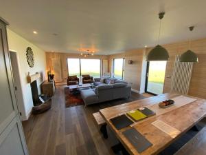a living room with a couch and a table at Porthdinllaen by Together Travel - Luxury 5-Bed Holiday Retreat in Pistyll