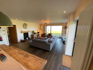a living room with a couch and a fireplace at Porthdinllaen by Together Travel - Luxury 5-Bed Holiday Retreat in Pistyll