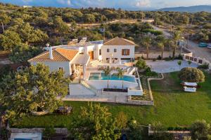 an aerial view of a house with a swimming pool at Villa Delfini - Elevated Sea Views by etouri in Prinés