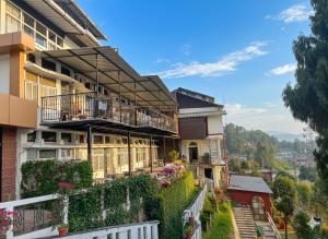 an apartment building with balconies and ivy at Cochrane Place By Teesta Hotels in Kurseong
