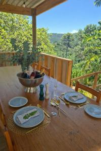 a wooden table with plates and a bowl on it at Forest Nature Spa in Plettenberg Bay