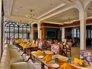 a restaurant with couches and tables and chairs at Cochrane Place By Teesta Hotels in Kurseong