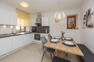 a kitchen and dining room with a wooden table and chairs at Ferienhaus Karin in Cortaccia