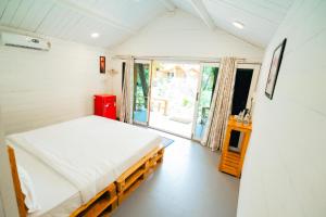 a small bedroom with a bed and a window at The Pearl Beach Resort in Canacona