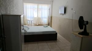 a small bedroom with a bed and a window at HOTEL LIVRAMENTO Maceió in Maceió
