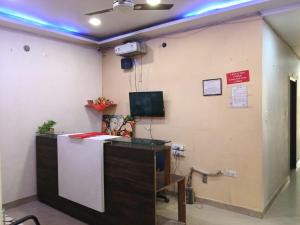 an office with a desk and a tv on a wall at Hotel Sasa Paradise in Lucknow