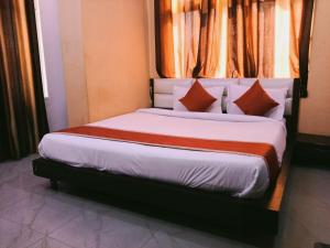 a bedroom with a large bed with orange curtains at Hotel Sasa Paradise in Lucknow