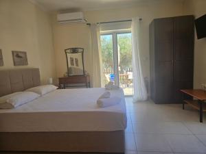 a bedroom with a large bed and a sliding glass door at Sunset View Studios in Agios Nikitas