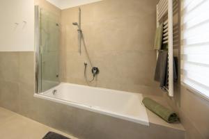 a bathroom with a bath tub with a shower at Ferienhaus Karin in Cortaccia +3 photos