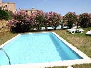 una piscina in un cortile con sedie e alberi di Holiday home in Sardinia with pool and terrace with country views a Stintino
