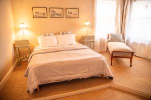 a bedroom with a large bed and a chair at Le Vieux Castel in Roumoules