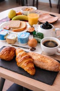 a table with a breakfast of croissants bread and coffee at Enzo Hotels Chartres Mainvilliers in Chartres +19 photos