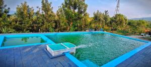 a swimming pool with a boat in the water at wild grove resorts in Varagampadi