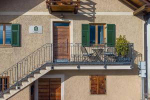 a building with a balcony with chairs on it at Ferienhaus Karin in Cortaccia