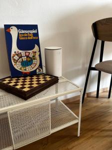 a white table with a box and a chessboard on it at P4 Crema Home in Crema +19 photos