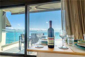 a bottle of wine sitting on a table with glasses at Emmari Luxury Suites in Episkopos