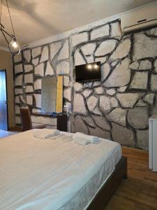 a bedroom with a stone wall with a bed at Hirmas boutique hotel in Tbilisi City