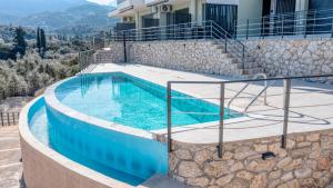 a swimming pool on the side of a house at Emmari Luxury Suites in Episkopos