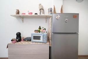 a kitchen with a refrigerator and a microwave at CHIARAGIULIA Camera Giulia Cabras in Càbras