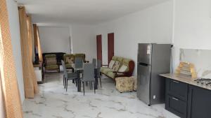 a kitchen with a table and chairs and a refrigerator at kooshal Seetul Flacq Flat in Centre de Flacq