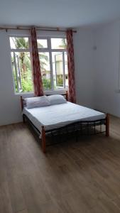 a bed in a room with a large window at kooshal Seetul Flacq Flat in Centre de Flacq