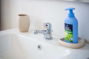 a bottle of detergent sitting on a bathroom sink at CHIARAGIULIA Camera Giulia Cabras in Càbras +19 photos