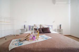 a bed with a tray of wine bottles and flowers on it at CHIARAGIULIA Camera Giulia Cabras in Càbras