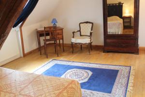 a room with a chair a table and a mirror at Chambres d'hôtes de Champendu in Azy-le-Vif