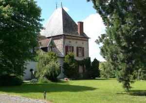 an old house with a turret on a green field at Chambres d'hôtes de Champendu in Azy-le-Vif