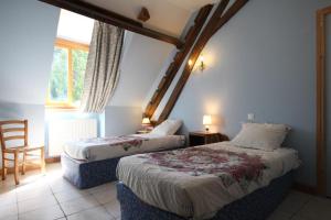 a bedroom with two beds and a chair and a window at Chambres d'hôtes de Champendu in Azy-le-Vif +23 photos
