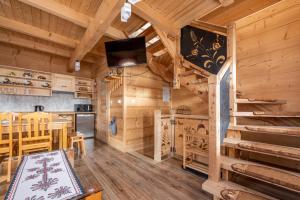 a dining room and kitchen in a log cabin at Chochołowskie Domki in Chochołów