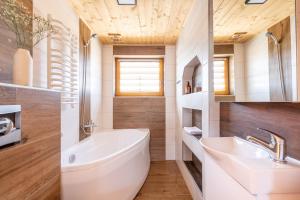 a bathroom with a white tub and a sink at Chochołowskie Domki in Chochołów +86 photos