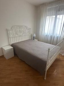 a bedroom with a white bed and a window at Ada Corner in Belgrade