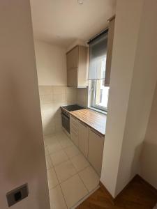 a small kitchen with white cabinets and a window at Ada Corner in Belgrade