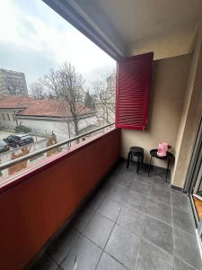 a balcony with a large window with two chairs and a table at Ada Corner in Belgrade