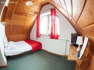 a bedroom with a bed and a window with red curtains at Willa Jordanówka in Czorsztyn