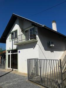 a white house with a balcony and a fence at Biser jezera in Gornja Šuma