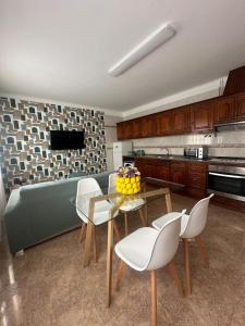 a kitchen with a table and chairs and a couch at Charm-In Apartments in Vila Nova de Milfontes