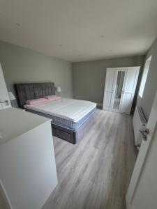 a bedroom with a bed and a wooden floor at Skellig View in Portmagee
