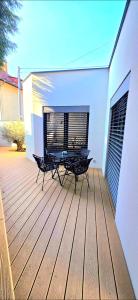 a wooden deck with two chairs on a house at Apartmán u Pivovaru in Rožnov pod Radhoštěm