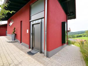 a red building with a door on the side of it at Rosy Holiday Home in Blossersberg with Private Terrace in Viechtach