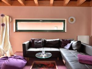 a living room with a leather couch and a window at Rosy Holiday Home in Blossersberg with Private Terrace in Viechtach