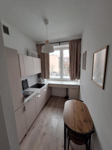 a small kitchen with a table and a window at Tatamka Hostel in Warsaw