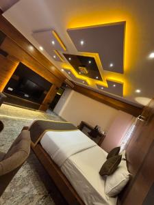 a bedroom with a bed and a flat screen tv at Hotel White Rock in Bangalore