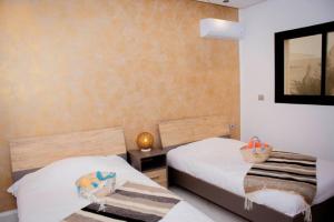 a bedroom with two beds and a mirror at Villa el Kasbah in Midoun +19 photos