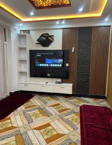 a living room with a tv and a large screen at Madina plaza 2 in Kabul